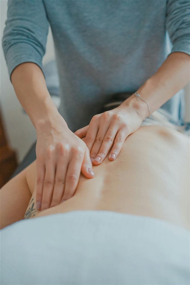Female hands massaging a patient's back